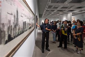 台灣美術院執行長李振明(左)為與會嘉賓導覽介紹《播種者》展出內容。