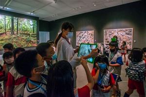 2_計畫結合豐富多元的藝術體驗，圖為學生參與高美館《人類世》導覽並體驗AR作品。