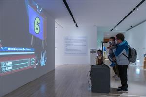 高美館《透景線》展場一隅，圖為互動作品〈AI造景師〉邀請觀眾「說」出想像中的風景畫。