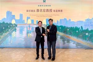 高美館館長顏名宏（左）自副市長李懷仁（右）手中接下黃土水《釋迦出山》銅像（複刻），象徵肩負起未來館務營運重責大任。